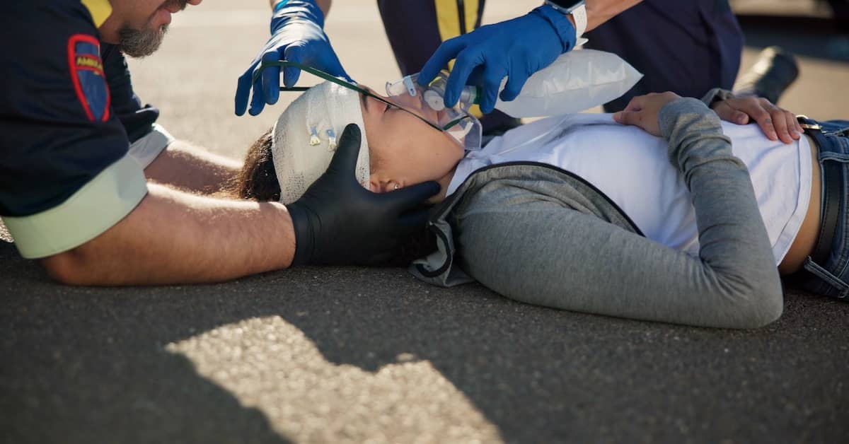 Paramedics treating a woman with a catastrophic injury | Burg Simpson