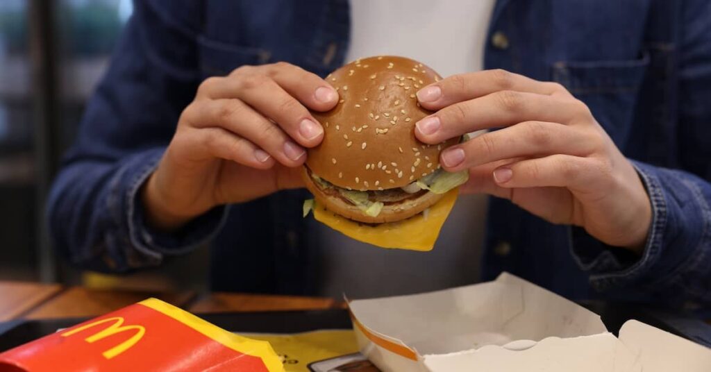 Man eating McDonald's Quarter Pounder sandwich | Burg Simpson