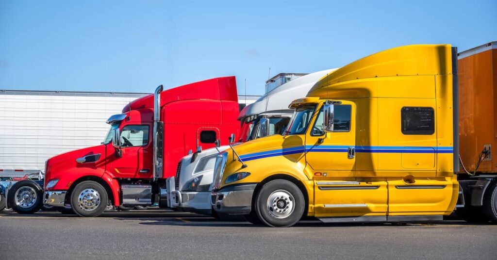 A fleet of semi-trucks in a trucking company lot | Burg Simpson