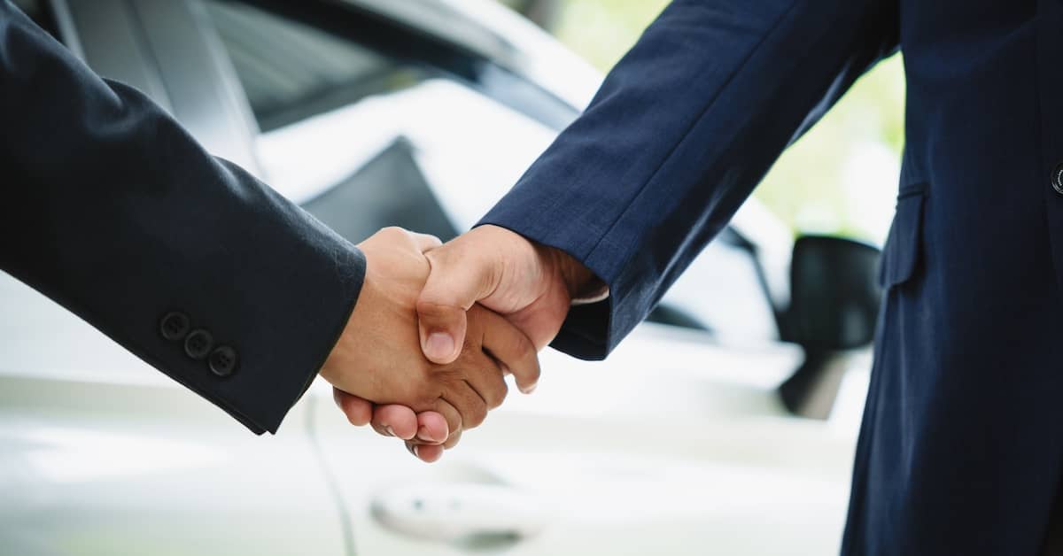 Shaking hands after reaching a car accident settlement | Burg Simpson